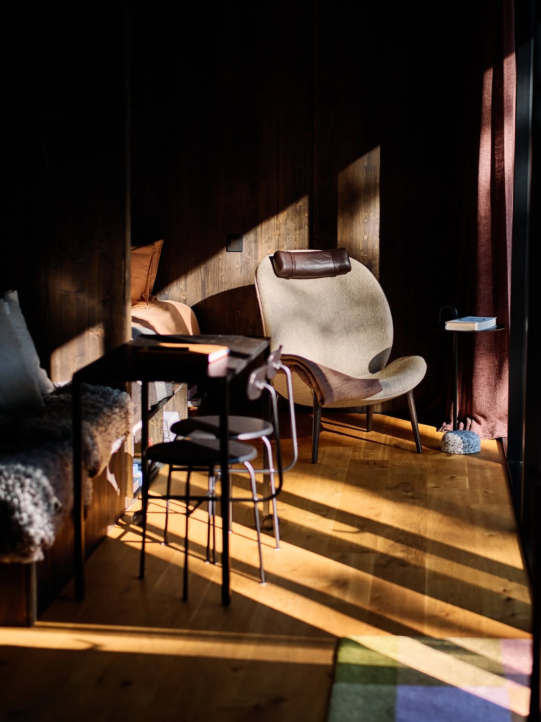 Interior of Hop Farm Beach cabin showing floor-to-ceiling windows framing the Swedish forest, designed by Mette Fredskild