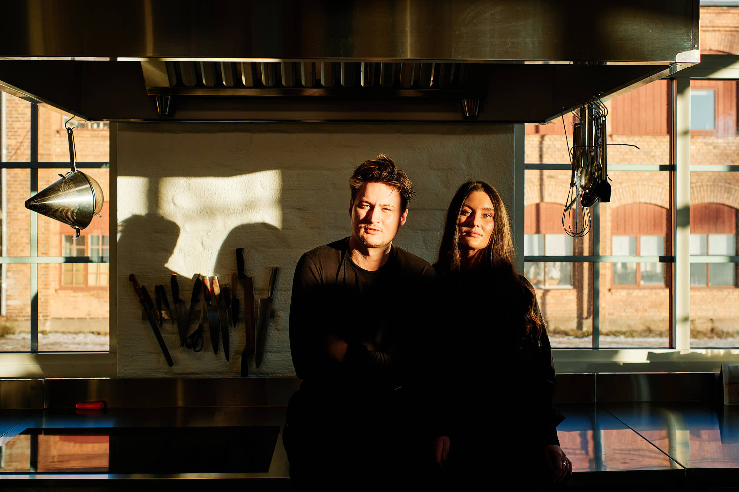 Rasmus and Evelina in the kitchen at Salt Studio Gävle, industrial backdrop with courtyard windows