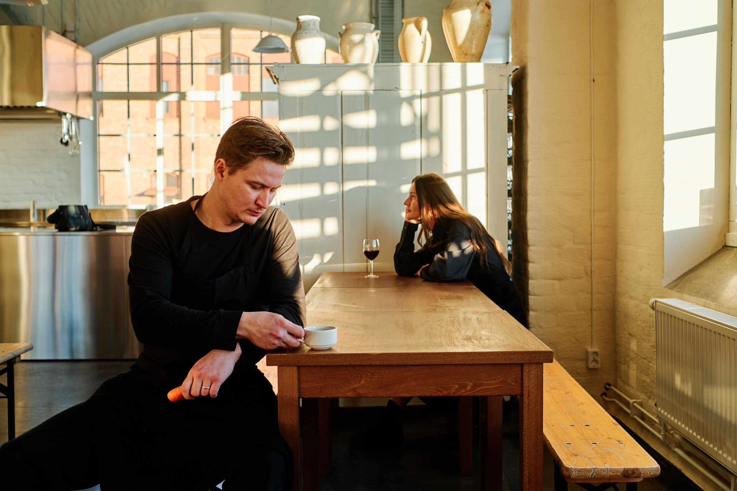 Rasmus and Evelina at Salt Studio Gävle, industrial windows and wooden tables in background