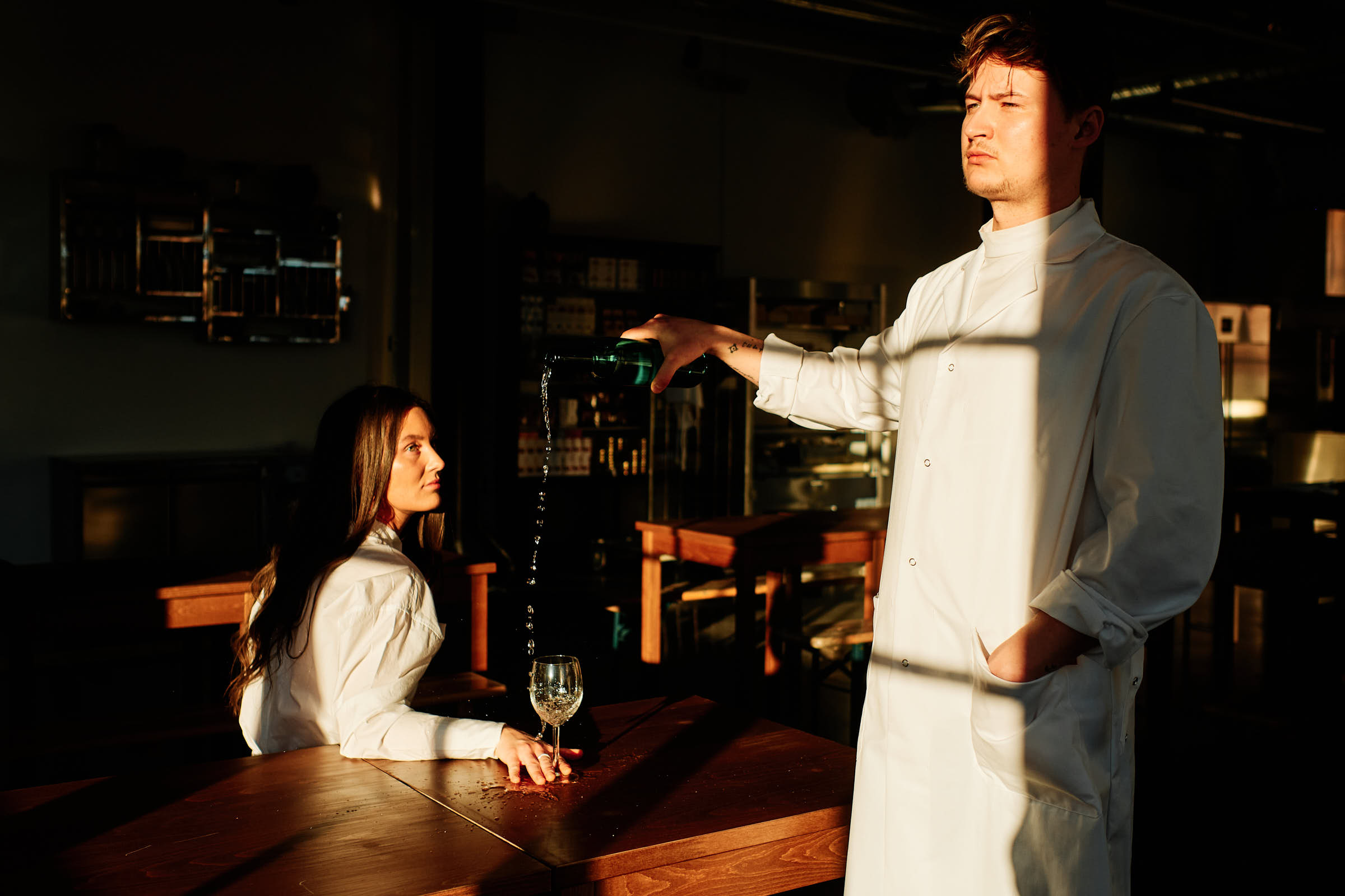 Rasmus pouring wine at Salt Studio Gävle, golden evening light across wooden table