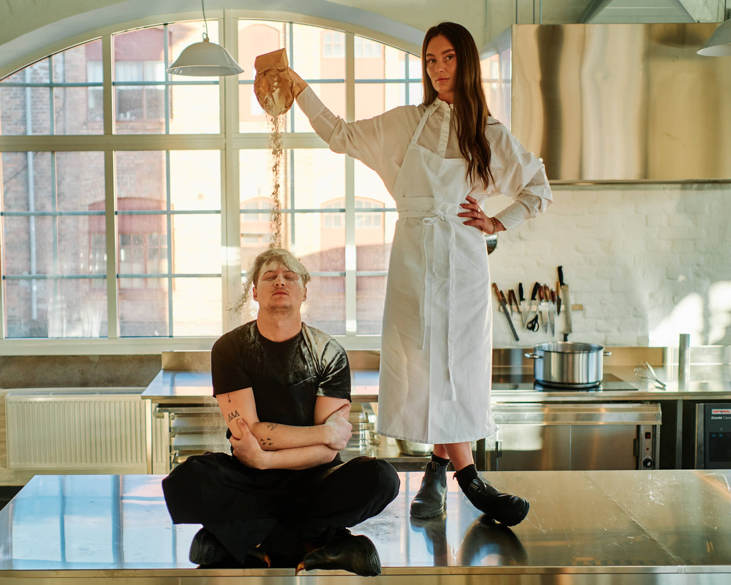Evelina pouring flour on Rasmus on the kitchen counter at Salt Studio Gävle