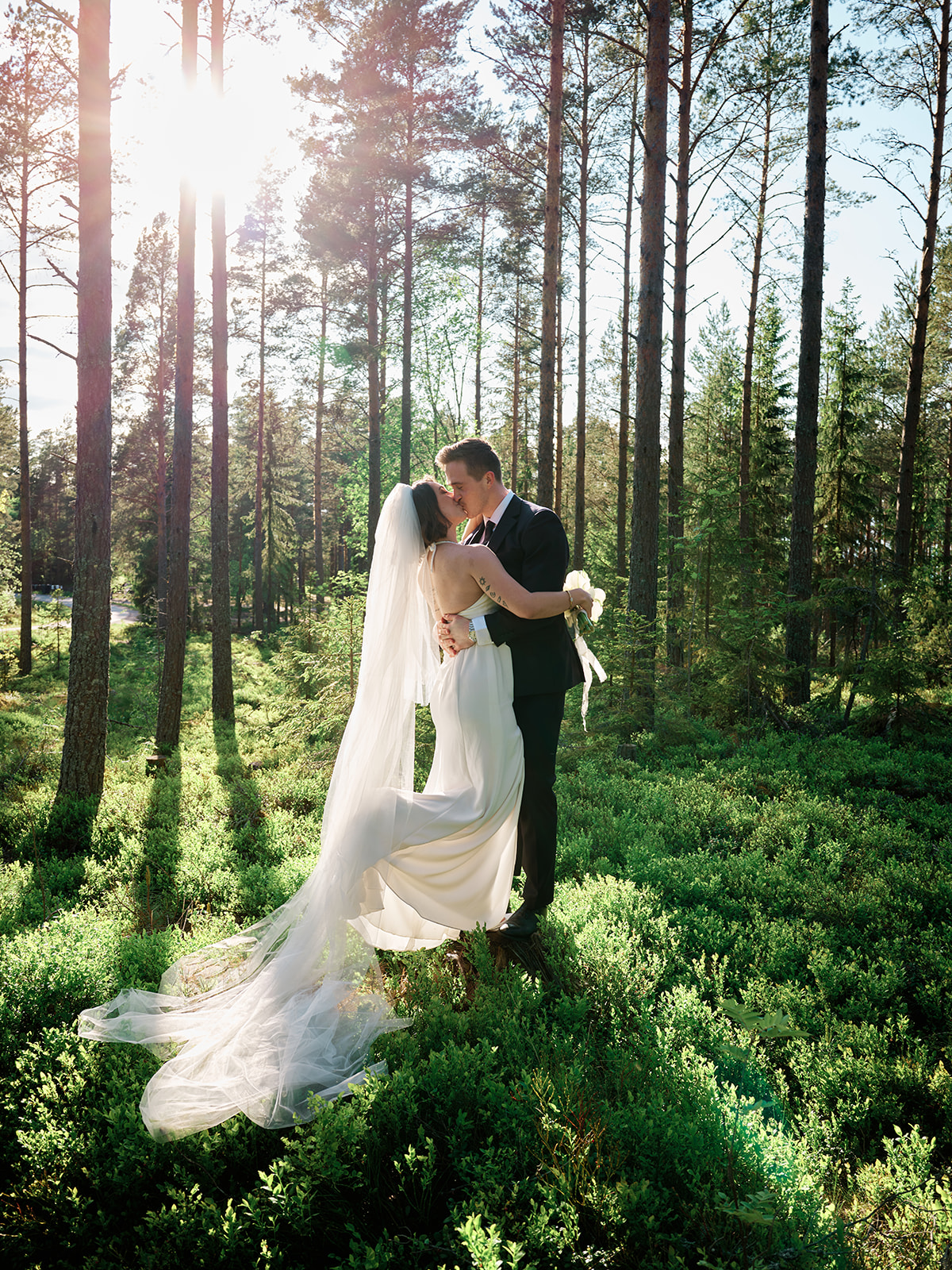 Elopement couple walking through golden hour landscape on Sweden's Baltic coast